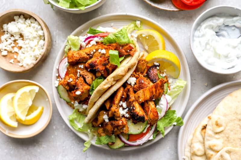 two chicken gyro pita wraps on a plate.
