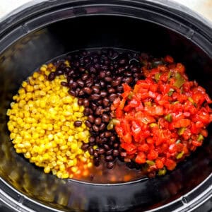corn, black beans, and diced tomatoes with green chiles in a crockpot.