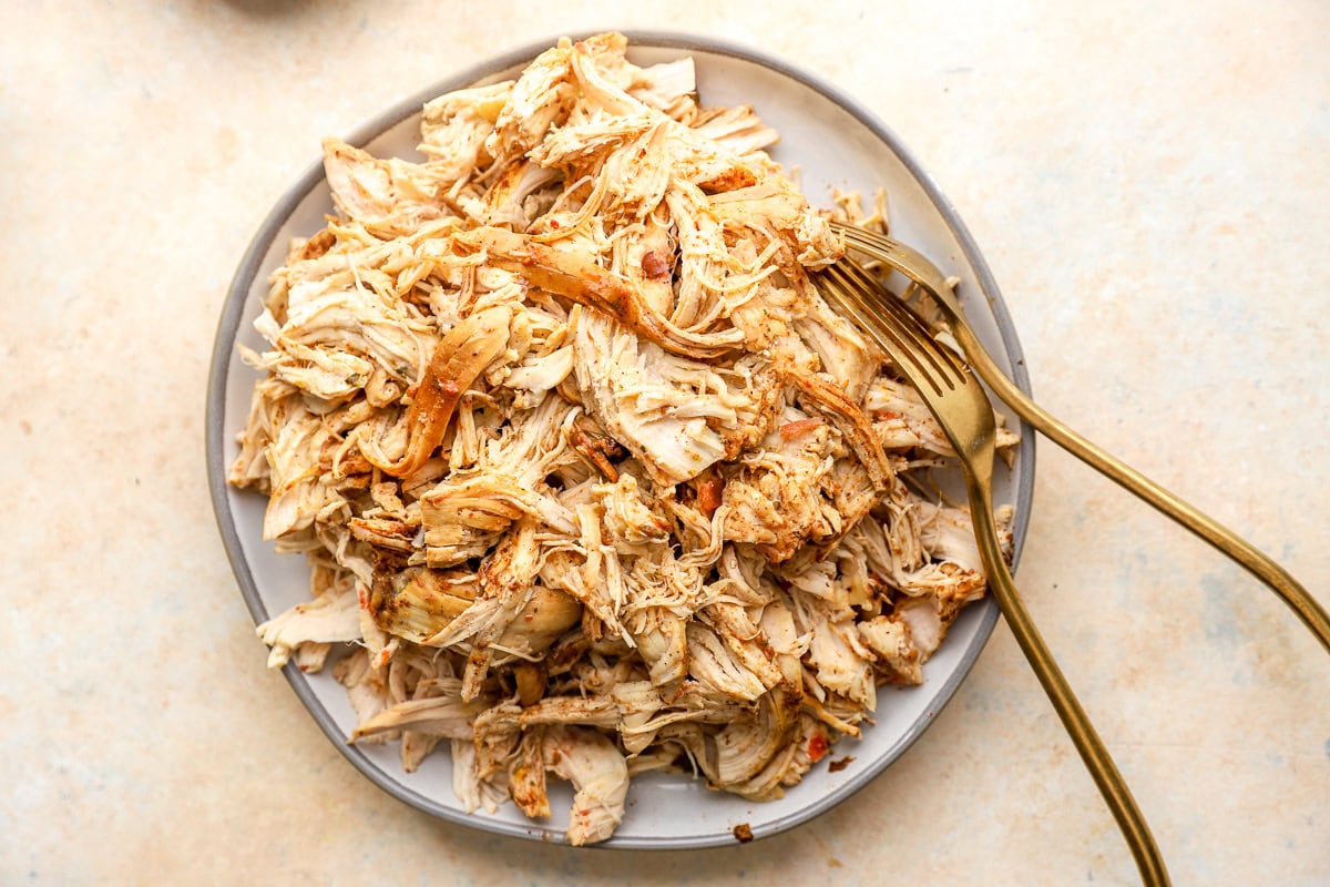 shredded chicken on a plate with two forks.