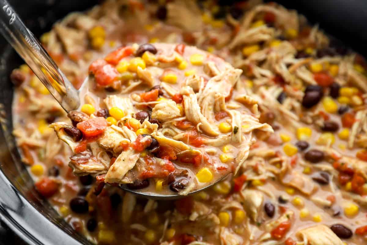 lifting a ladleful of Southwest crack chicken chili from a crockpot.