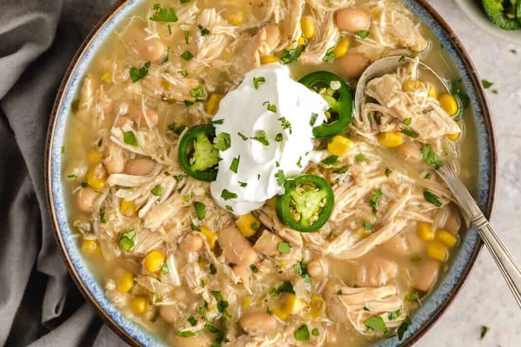 Slow cooker white chicken chili with sour cream and jalapenos.