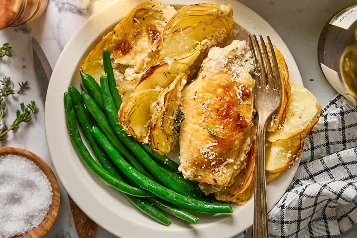 a plate of chicken thighs, potatoes Dauphinoise, and green beans.