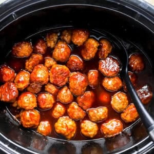 cooked grape jelly chicken meatballs in a crockpot.