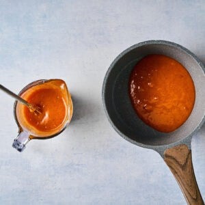 apricot marinade divided between a liquid measuring cup and a saucepan.