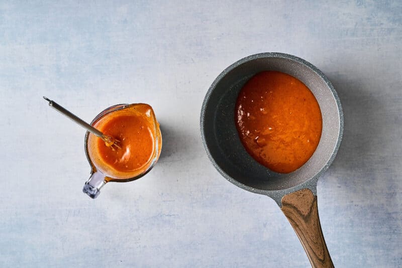 apricot marinade divided between a liquid measuring cup and a saucepan.