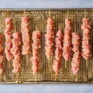 seasoned raw chicken bites on skewers.