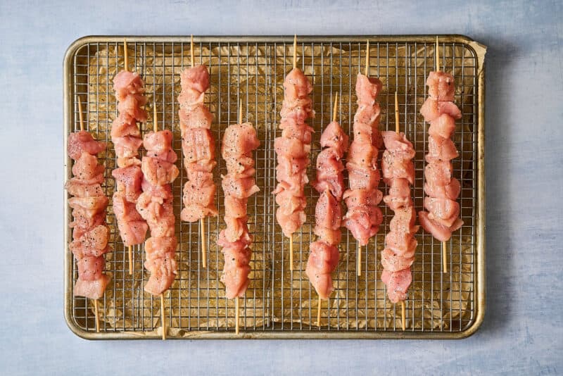 seasoned raw chicken bites on skewers.