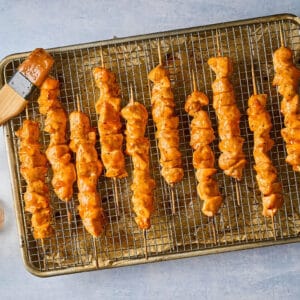 cooked apricot chicken skewers on a wire rack set in a baking sheet.