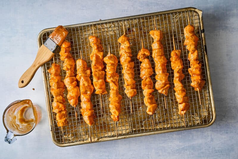 cooked apricot chicken skewers on a wire rack set in a baking sheet.