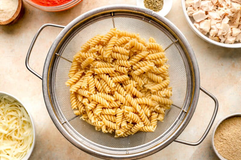 cooked rotini draining in a colander.
