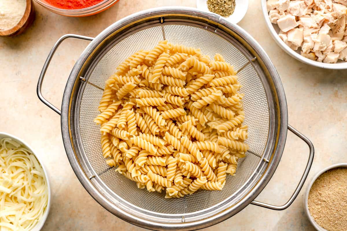cooked rotini draining in a colander.
