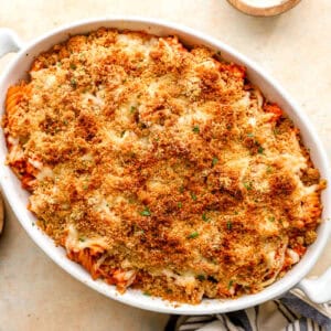 baked chicken parmesan casserole in a baking dish with parsley on the side.