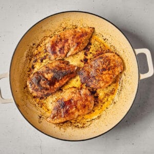 searing chicken breasts in a pan.