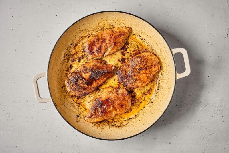 searing chicken breasts in a pan.