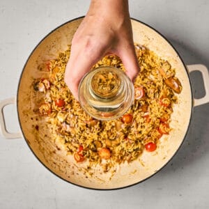 deglazing a pan of orzo and veggies with wine.