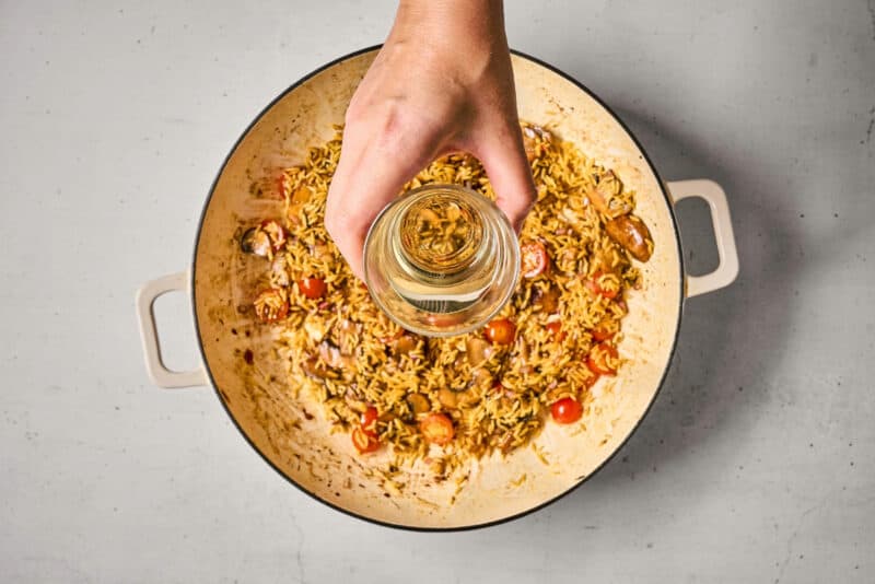 deglazing a pan of orzo and veggies with wine.
