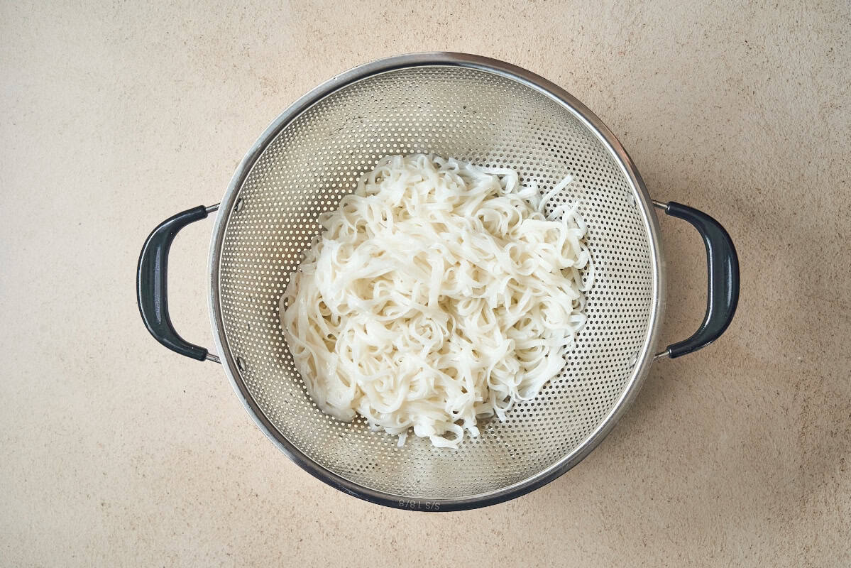 strained cooked rice noodles in a colander.