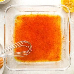chicken marinade in a glass dish with a whisk.