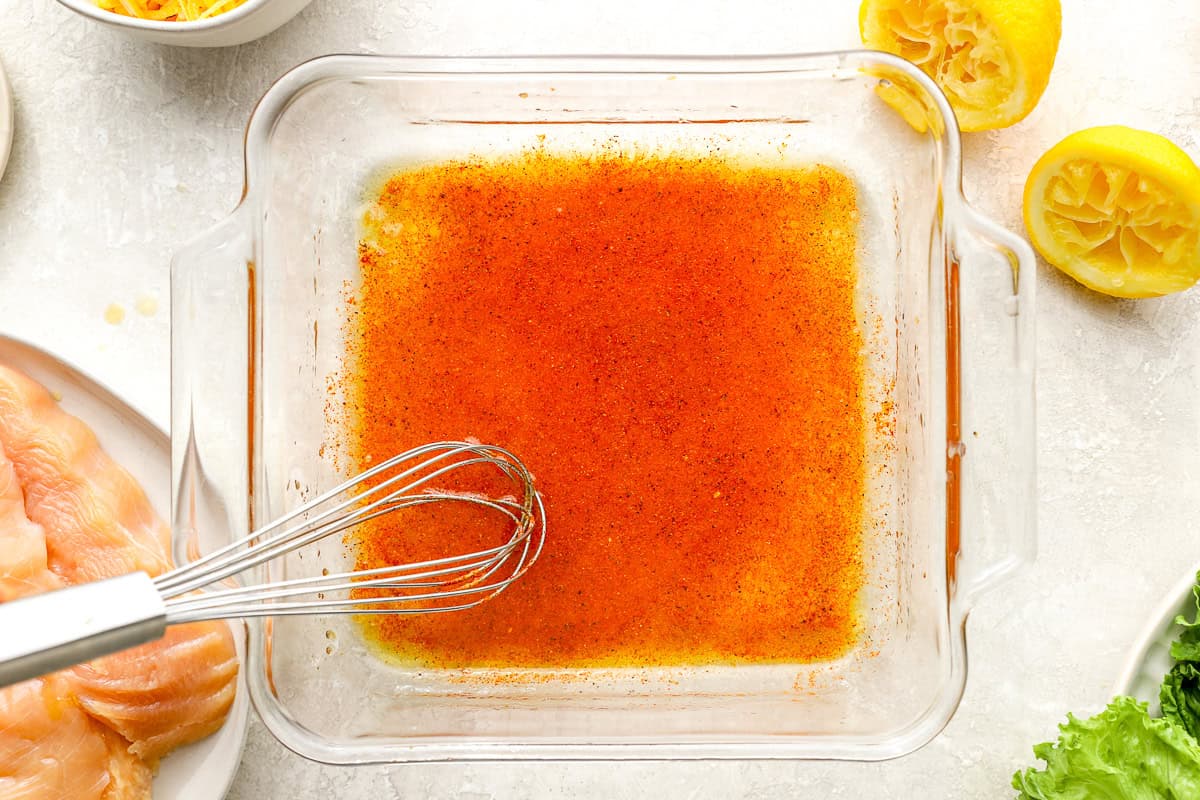 chicken marinade in a glass dish with a whisk.
