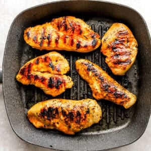 grilled marinated chicken breasts in a grill pan.