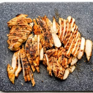 sliced grilled chicken breasts on a cutting board.