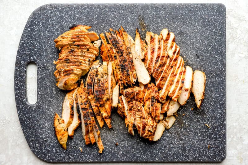 sliced grilled chicken breasts on a cutting board.