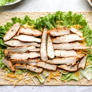 lettuce, cheese, and chicken slices laid out on a flatbread.