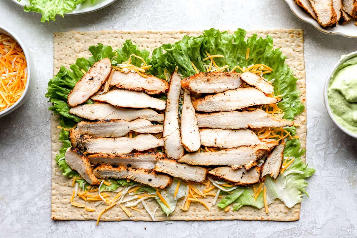 lettuce, cheese, and chicken slices laid out on a flatbread.
