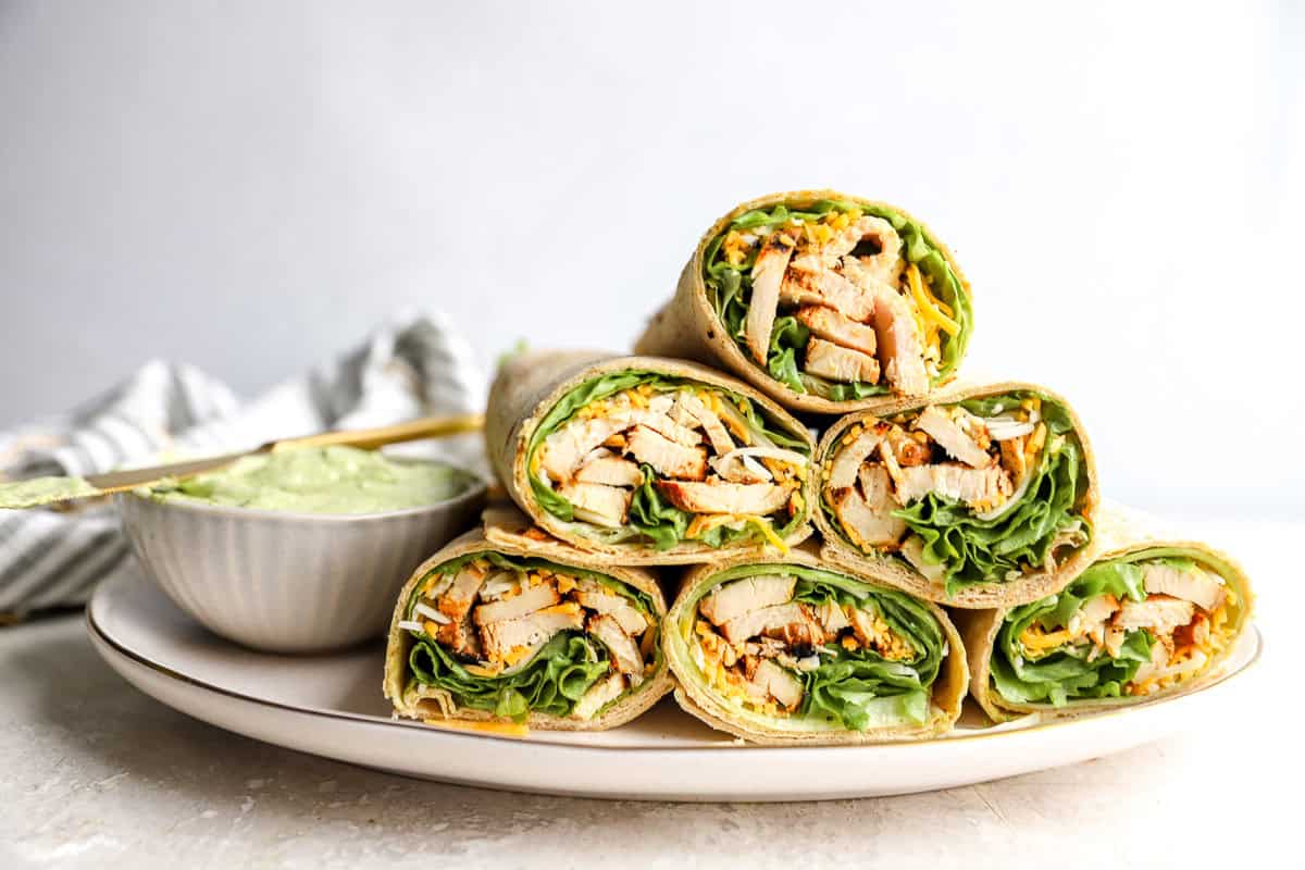 a pyramid of chick fil a cool wraps on a white plate with avocado lime ranch dipping sauce.