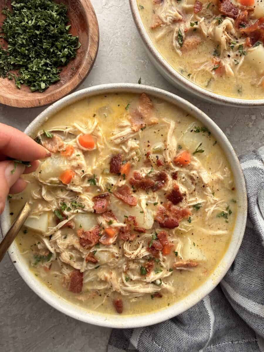 Garnishing a bowl of chicken potato soup.