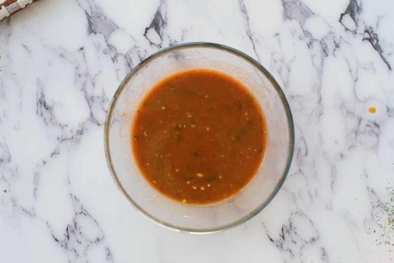 Orange BBQ sauce in a glass bowl.