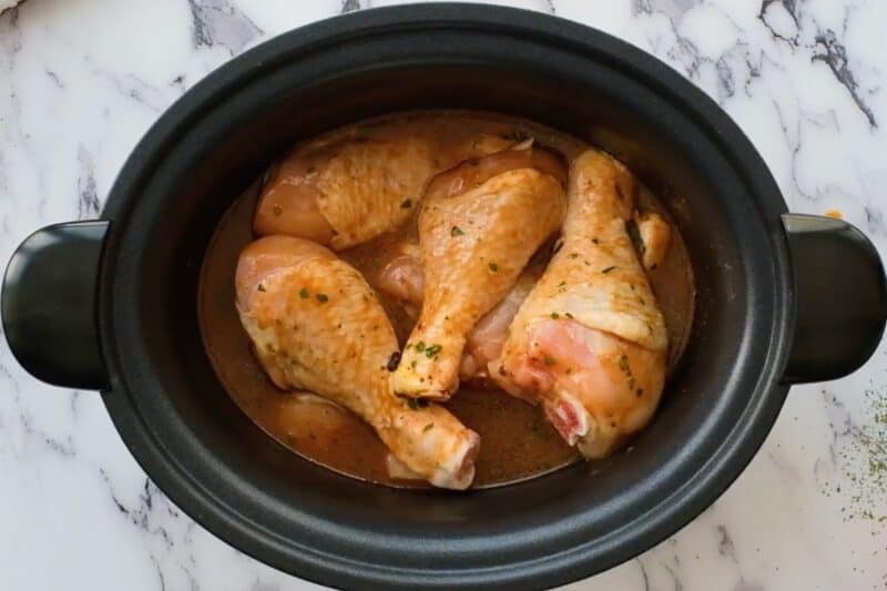 Drumsticks coated in BBQ sauce, in a slow cooker.