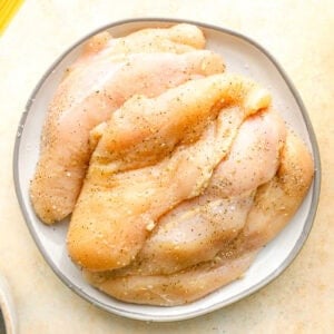 seasoned thin-sliced chicken breasts on a plate.