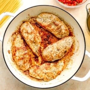 seared seasoned chicken breasts in a pan.