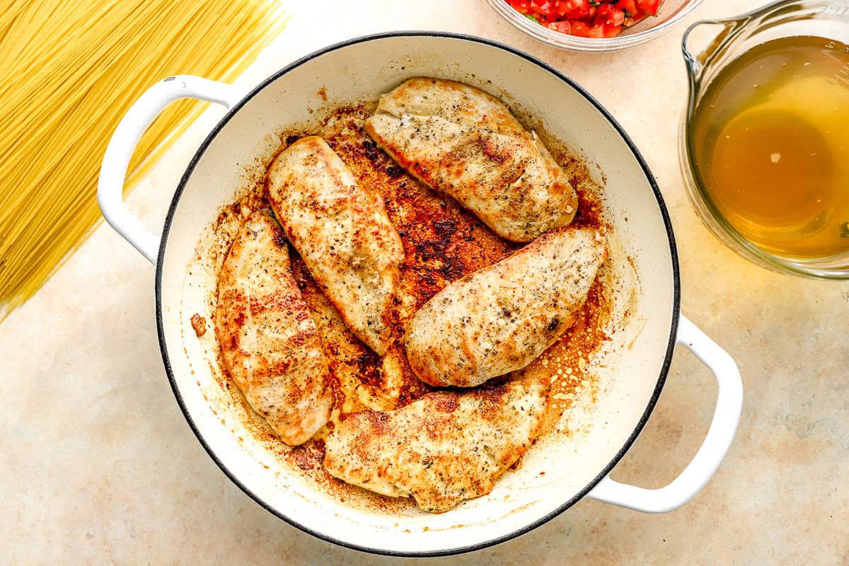 seared seasoned chicken breasts in a pan.