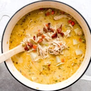 creamy chicken and potato soup in a dutch oven with bacon.