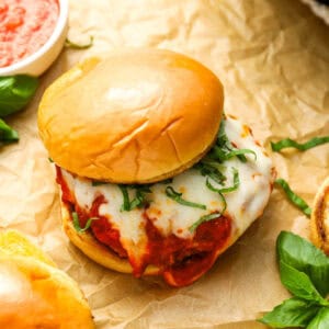 Chicken parmesan burger on parchment paper.