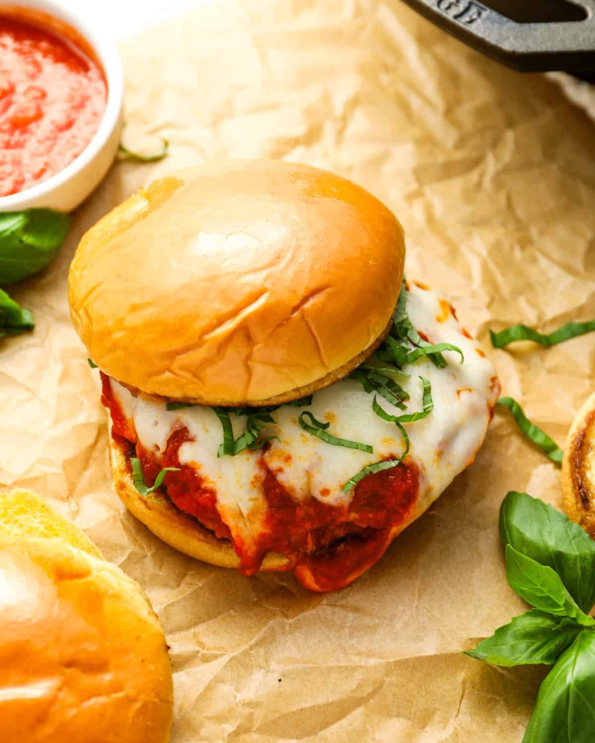 Chicken parmesan burger on parchment paper.