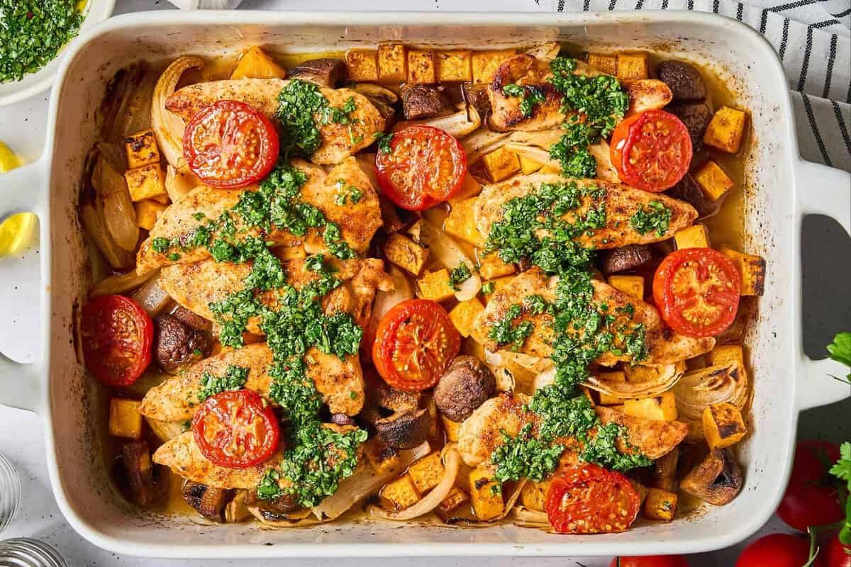 overhead view of sheet pan chicken tenders and veggies with hot honey chimichurri.