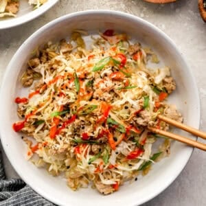 Chicken egg roll in a bowl with chopsticks.