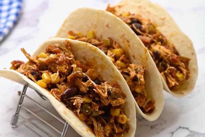 Crockpot Mexican shredded chicken served in soft tacos.