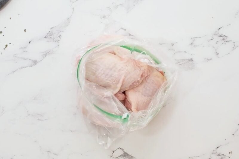 Raw chicken thighs in a resealable bag.