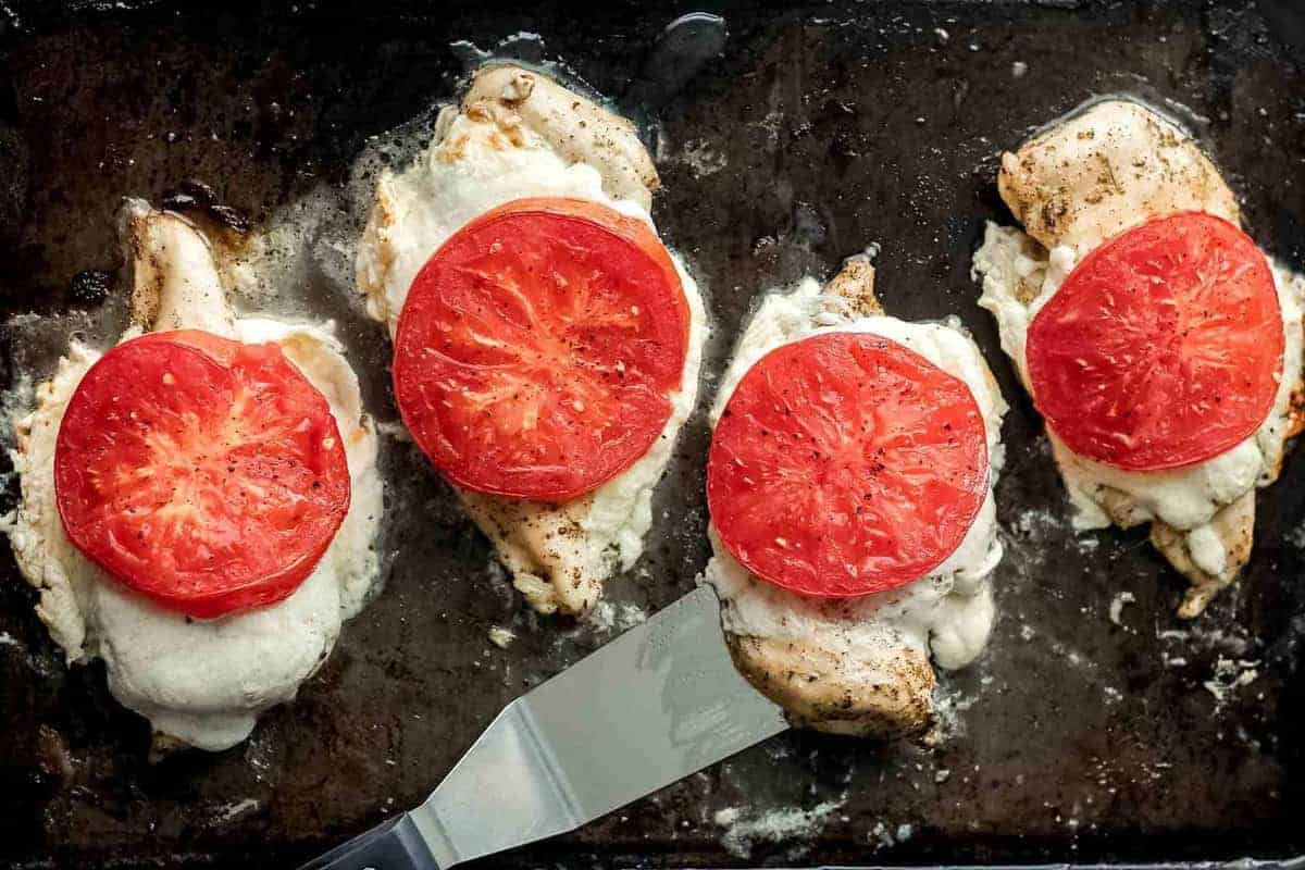 Baked caprese chicken topped with tomatoes and mozzarella.