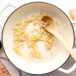 Onion, ginger and garlic cooking in a skillet.