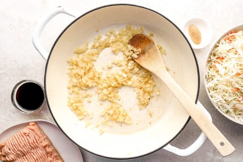 Onion, ginger and garlic cooking in a skillet.