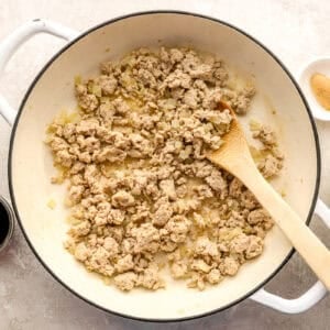 Browning ground chicken in a skillet.
