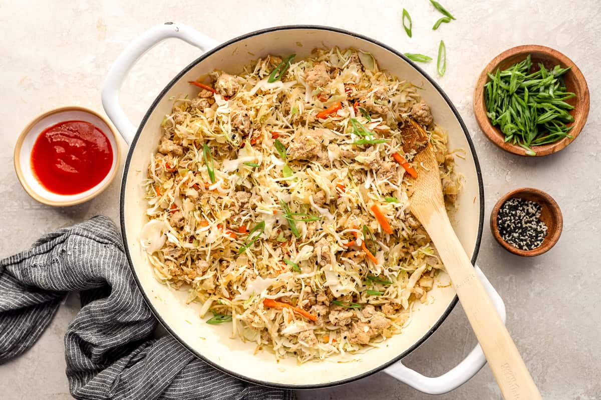 Coleslaw mix stirred into the skillet.