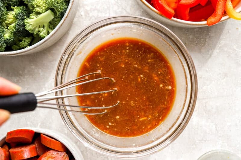 Stir fry sauce being whisked together in a glass bowl.