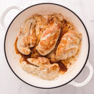 Browned chicken breasts in a skillet.