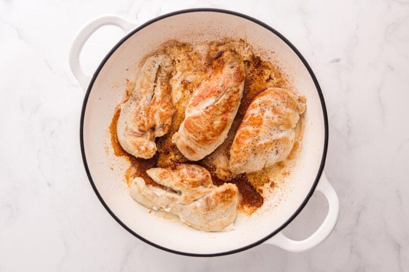 Browned chicken breasts in a skillet.